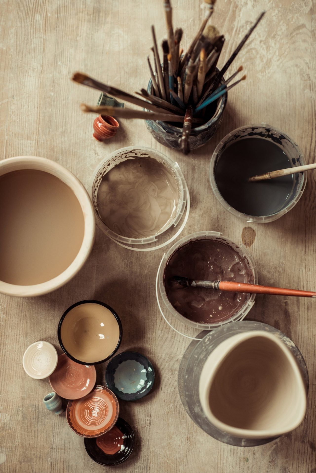 close-up-of-paint-brushes-with-pottery-tools-in-bowls-on-table.jpg